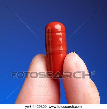 Holding single red capsule View Large Photo Image Stock Photo - Holding single red capsule. Fotosearch