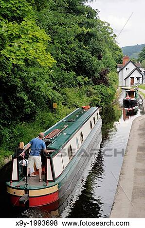 Holiday narrowboats pass on the Llangollen Canal at Wharf Hill, Llangollen, Denbighshire, Wales, UK. View Large Photo Image Stock Photo - Holiday narrowboats pass on the Llangollen Canal at Wharf Hill, Llangollen, Denbighshire, Wales, UK.. Fotosearch