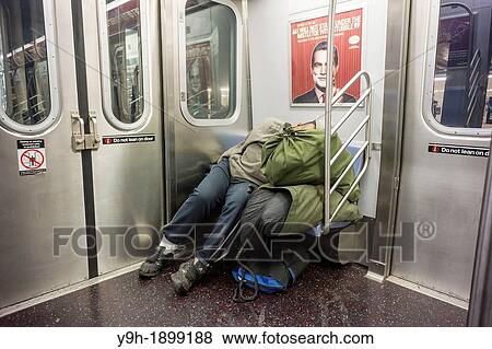 Homeless man escapes the cold and sleeps in a subway car in New York View Large Photo Image Stock Photo - Homeless man escapes the cold and sleeps in a subway car in New York. Fotosearch