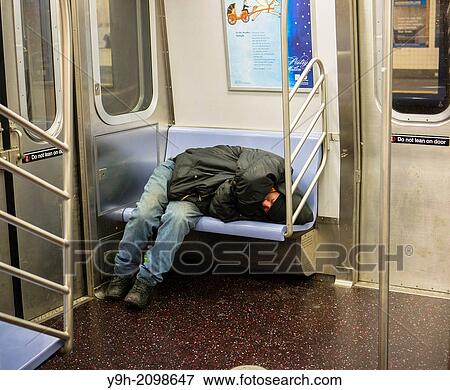 Homeless man takes up several seats as he sleeps in a subway car in New York View Large Photo Image Stock Photo - Homeless man takes up several seats as he sleeps in a subway car in New York. Fotosearch