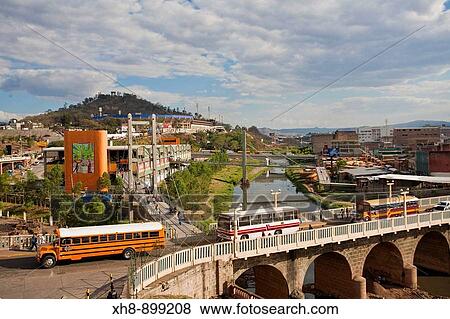 Stock Photo - Honduras, Tegucigalpa, Buses crossing Bridge over Rio Choluteca, Mercada La Isla, La Isla Market, National stadium, Estadio Nacional, Tiburchio Carias Andino, and Parque La Paz. Fotosearch