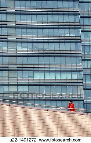 Stock Image - Hong Kong: a man at the phone on the rooftop of the Hong Kong Cultural Centre. Fotosearch