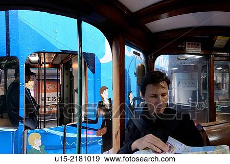 Hong Kong, China, Asia. European female tourist reading a map while on a tram on Hong Kong Island. View Large Photo Image Stock Photo - Hong Kong, China, Asia. European female tourist reading a map while on a tram on Hong Kong Island.. Fotosearch