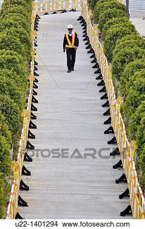 Hong Kong: guard at the works for the construction of the new pier on Victoria Harbour, in Central View Large Photo Image Picture - Hong Kong: guard at the works for the construction of the new pier on Victoria Harbour, in Central. Fotosearch