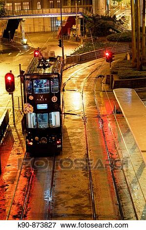 Hong Kong tram (seen from above) stopping at a station in the night besides a red light in Causeway Bay during a rainy day, Hong Kong Island, China, East Asia View Large Photo Image Stock Photo - Hong Kong tram (seen from above) stopping at a station in the night besides a red light in Causeway Bay during a rainy day, Hong Kong Island, China, East Asia. Fotosearch