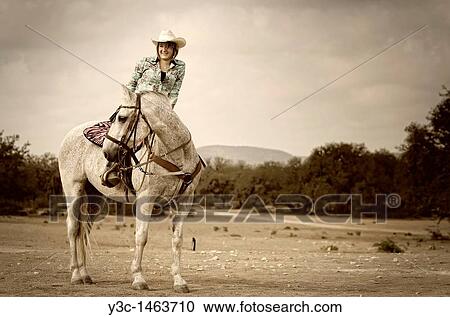 Stock Image - Horseback riding cowgirl. Fotosearch