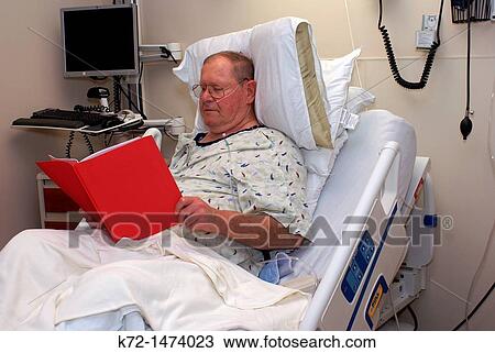 Hospital patient in bed reading information View Large Photo Image Stock Image - Hospital patient in bed reading information. Fotosearch