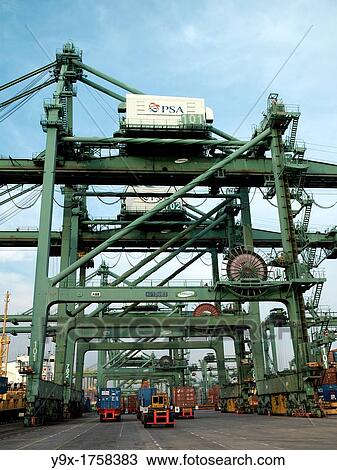 Stock Image - Huge machinery for the transport of containers from cargo liners to the port at the Port of Singapore Authority PSA in Singapore. Fotosearch