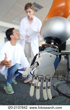 Stock Image - Humanoid robot for automotive assembly tasks in collaboration with people and and LWR robot, using haptic teleoperation with force feedback.. Fotosearch