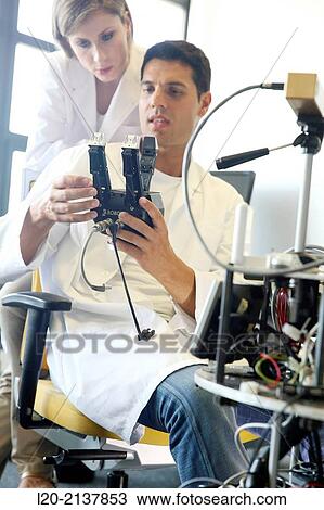Stock Image - Humanoid robot for automotive assembly tasks in collaboration with people and and LWR robot, using haptic teleoperation with force feedback.. Fotosearch