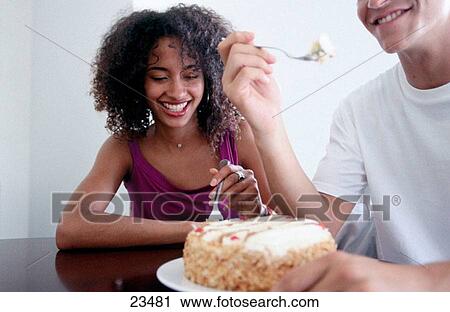 Hungry young couple eating cake with forks View Large Photo Image Stock Image - Hungry young couple eating cake with forks. Fotosearch