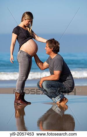 Husband caressing wife's pregnant stomach. View Large Photo Image Stock Image - Husband caressing wife's pregnant stomach.. Fotosearch