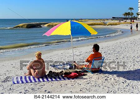 Picture - Husband wife sitting at the beach relaxing and enjoying each other.. Fotosearch