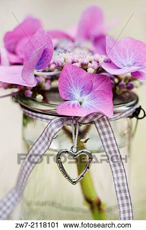 Hydrangea Flowers In Glass Vase Decorated With A Metal Heart And