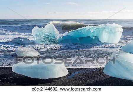 Iceberg on black vulcanic beach. North Atlantic beach of the ice lagoon Joekulsarlon at glacier Breithamerkurjoekull, Vatnajoekull NP. europe, northern europe, iceland, march. View Large Photo Image Stock Image - Iceberg on black vulcanic beach. North Atlantic beach of the ice lagoon Joekulsarlon at glacier Breithamerkurjoekull, Vatnajoekull NP. europe, northern europe, iceland, march.. Fotosearch