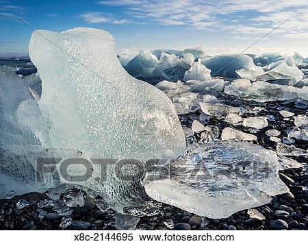 Iceberg on black vulcanic beach. North Atlantic beach of the ice lagoon Joekulsarlon at glacier Breithamerkurjoekull, Vatnajoekull NP. europe, northern europe, iceland, march. View Large Photo Image Stock Photography - Iceberg on black vulcanic beach. North Atlantic beach of the ice lagoon Joekulsarlon at glacier Breithamerkurjoekull, Vatnajoekull NP. europe, northern europe, iceland, march.. Fotosearch