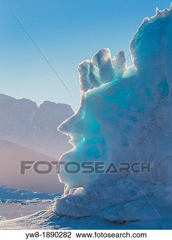 Stock Image - Icebergs, Scoresbysund, Greenland Face in Iceberg drifting in Scoresbysund, Sermersooq Municipality, Greenland. Fotosearch