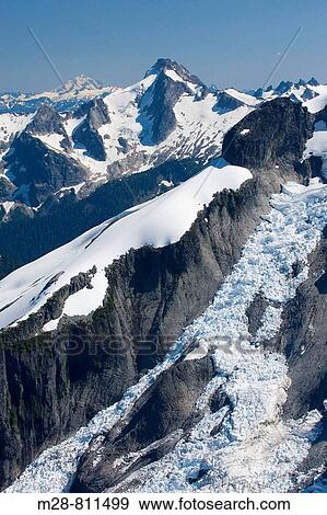 Icy Peak 7073 feet, 2156 meters displaying the Spillway Glacier, seen from the summit of Ruth Mountain Mount Blum is in the distance, North Cascades Washington View Large Photo Image Stock Photo - Icy Peak 7073 feet, 2156 meters displaying the Spillway Glacier, seen from the summit of Ruth Mountain Mount Blum is in the distance, North Cascades Washington. Fotosearch