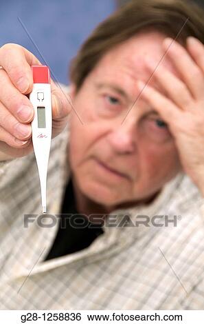 ill looking senior man holding a medical thermometer in front of him in one hand and his forehead in the other View Large Photo Image Stock Photograph - ill looking senior man holding a medical thermometer in front of him in one hand and his forehead in the other. Fotosearch