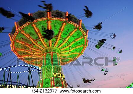 Stock Photo - Illuminated chain carousel at the Oktoberfest in Munich. Fotosearch