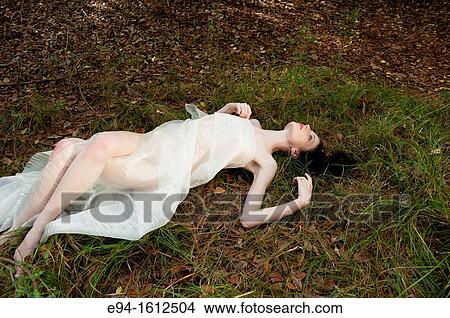 Image of a 20 year old woman wrapped in white fabric in a forest setting lying on the ground View Large Photo Image Picture - Image of a 20 year old woman wrapped in white fabric in a forest setting lying on the ground. Fotosearch