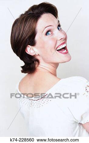 Stock Image - image of woman looking over her shoulder and laughing. Fotosearch