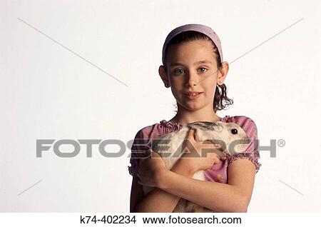 Picture - image of young girl with bunny rabbit. Fotosearch