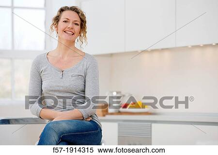 Independent young woman sitting her kitchen View Large Photo Image Stock Photography - Independent young woman sitting her kitchen. Fotosearch