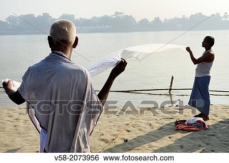 Stock Photograph - India, Bihar, Sonepur, Men drying a dhoti on the banks of the Ganges.. Fotosearch