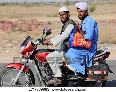 Stock Image - India, Rajasthan, men on motorcycle. Fotosearch