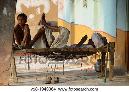 India, Rajasthan, Tonk region, Grandfather and grandson resting on a charpoy. View Large Photo Image Picture - India, Rajasthan, Tonk region, Grandfather and grandson resting on a charpoy.. Fotosearch