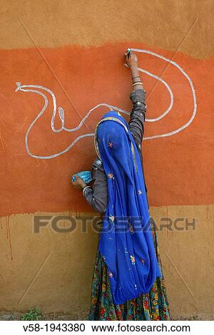 India, Rajasthan, Tonk region, Woman painting clay walls prior to Diwali festival. View Large Photo Image Stock Image - India, Rajasthan, Tonk region, Woman painting clay walls prior to Diwali festival.. Fotosearch