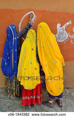 India, Rajasthan, Tonk region, Women painting clay walls prior to Diwali festival. View Large Photo Image Stock Image - India, Rajasthan, Tonk region, Women painting clay walls prior to Diwali festival.. Fotosearch
