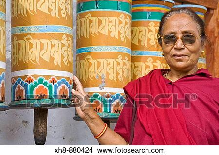Picture - India, Sikkim, Tashiding, Tashiding Gompa, Woman spinning prayer wheel. Fotosearch