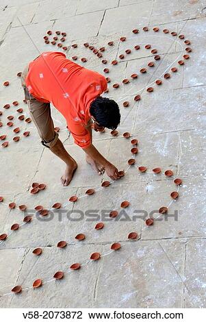 India, Uttar Pradesh, Varanasi, Dev Deepawali festival, Hindu devotee setting earthen lamps. View Large Photo Image Stock Image - India, Uttar Pradesh, Varanasi, Dev Deepawali festival, Hindu devotee setting earthen lamps.. Fotosearch