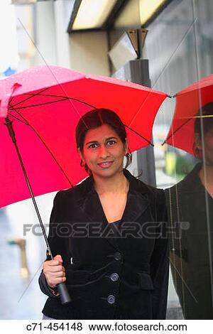 Indian businesswoman with umbrella in rain View Large Photo Image Stock Photo - Indian businesswoman with umbrella in rain. Fotosearch