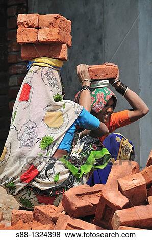 Indian construction workers carry heavy brick View Large Photo Image Stock Photo - Indian construction workers carry heavy brick. Fotosearch