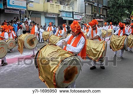 Indian girls & men wearing headgear called feta and white kurta pajamas and playing musical instrument called? dhol-taash? during Anant Chaturdashi Ganpati, Visarjan Miravnuk, Pune, Maharashtra, India View Large Photo Image Stock Image - Indian girls & men wearing headgear called feta and white kurta pajamas and playing musical instrument called? dhol-taash? during Anant Chaturdashi Ganpati, Visarjan Miravnuk, Pune, Maharashtra, India. Fotosearch