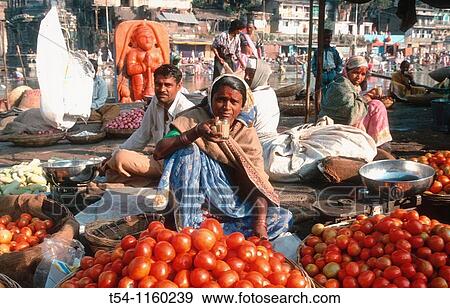 Stock Photo - Indian woman drinking chai at their market stall in Nasik. Fotosearch