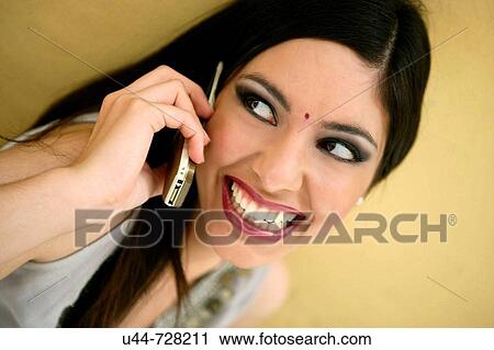 Indian woman with a cell phone talking and smiling View Large Photo Image Stock Image - Indian woman with a cell phone talking and smiling. Fotosearch
