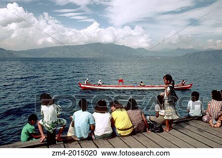 INDONESIA, SUMATRA, LAKE TOBA, SAMOSIR ISLAND, CHILDREN ON JETTY WITH BOAT IN BACKGROUND. View Large Photo Image Stock Image - INDONESIA, SUMATRA, LAKE TOBA, SAMOSIR ISLAND, CHILDREN ON JETTY WITH BOAT IN BACKGROUND.. Fotosearch