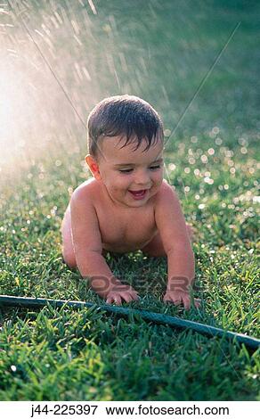 Infant boy playing with water hose in the garden View Large Photo Image Stock Photo - Infant boy playing with water hose in the garden. Fotosearch