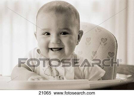 Stock Photography - Infant boy sitting on a high chair smiling. Fotosearch