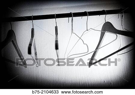 Inside a closet with wooden and metal hangers. View Large Photo Image Stock Image - Inside a closet with wooden and metal hangers.. Fotosearch