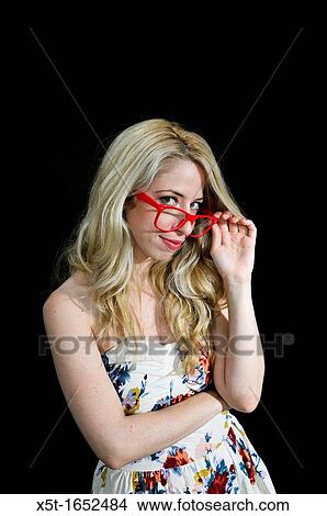 Intelligent blond woman with red glasses on black background View Large Photo Image Picture - Intelligent blond woman with red glasses on black background. Fotosearch