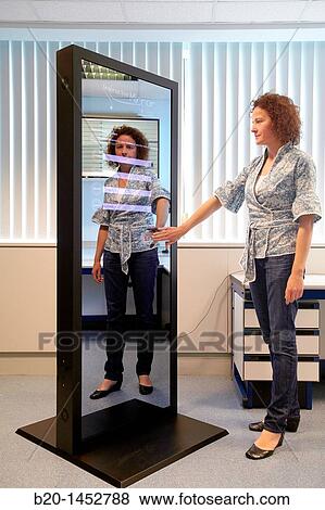 Interactive mirror that allows the person standing in front of it to see a simulated view of how the clothes they wish to buy would look when they wear them without trying the clothes on, Internet of Things lab, Tecnalia Research & Innovation View Large Photo Image Stock Photo - Interactive mirror that allows the person standing in front of it to see a simulated view of how the clothes they wish to buy would look when they wear them without trying the clothes on, Internet of Things lab, Tecnalia Research & Innovation. Fotosearch