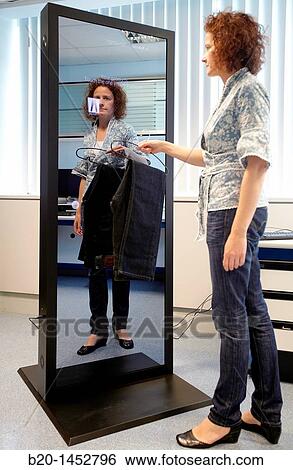 Interactive mirror that allows the person standing in front of it to see a simulated view of how the clothes they wish to buy would look when they wear them without trying the clothes on, Internet of Things lab, Tecnalia Research & Innovation View Large Photo Image Stock Photograph - Interactive mirror that allows the person standing in front of it to see a simulated view of how the clothes they wish to buy would look when they wear them without trying the clothes on, Internet of Things lab, Tecnalia Research & Innovation. Fotosearch
