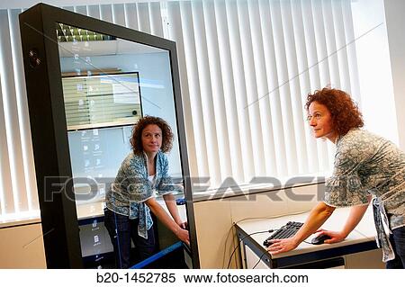Stock Photography - Interactive mirror that allows the person standing in front of it to see a simulated view of how the clothes they wish to buy would look when they wear them without trying the clothes on, Internet of Things lab, Tecnalia Research & Innovation. Fotosearch