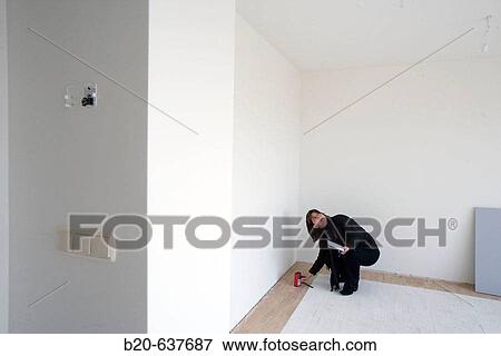 Interior decorator taking measures in empty room View Large Photo Image Stock Photo - Interior decorator taking measures in empty room. Fotosearch