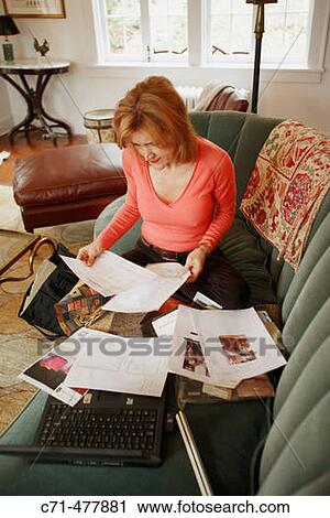 Stock Image - Interior decorator viewing designs on couch.. Fotosearch